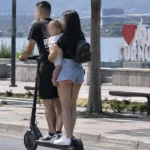 Bărbat pe trotinetă și femeie cu copil în brațe, pe străzile din Drobeta-Turnu Severin